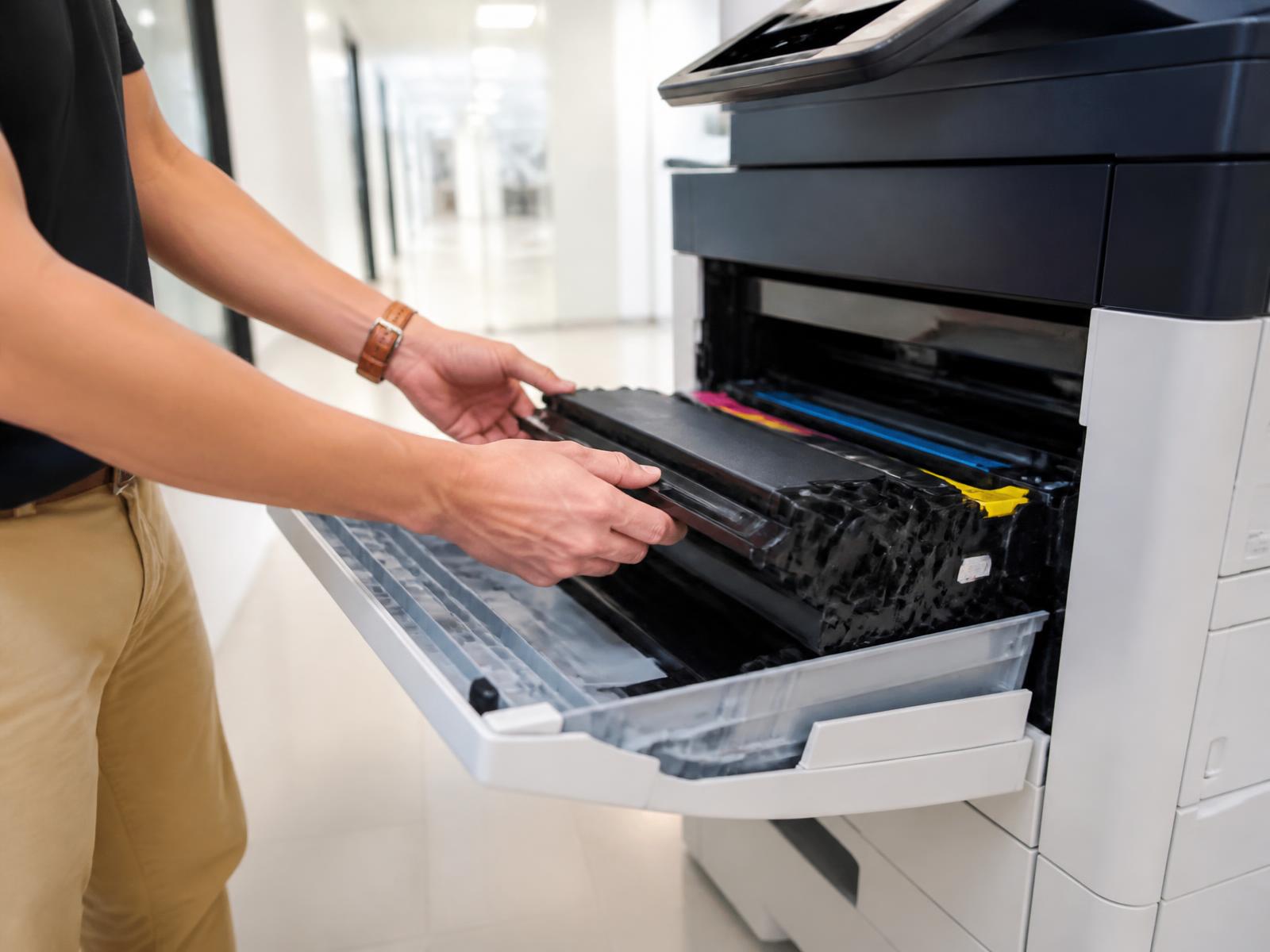 Monteur vervangt toner in een netwerkprinter op kantoor